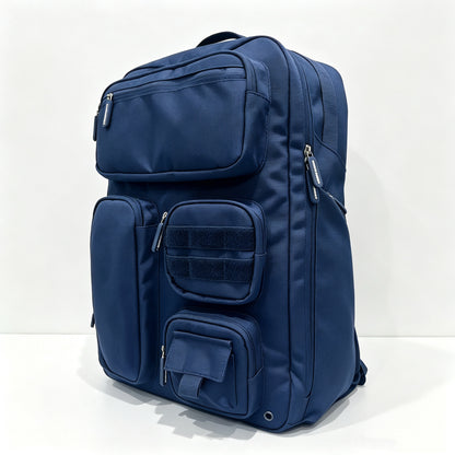 A navy blue multi-compartment backpack with multiple zippered pockets and a hook-and-loop panel, photographed on a clean white background.